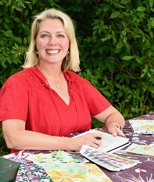 Ellen Morse sitting with her sketchbook and artwork 